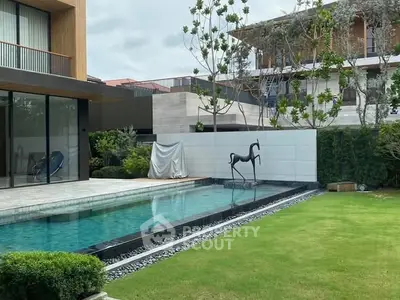 Luxurious modern home with sleek pool and lush garden, perfect for relaxation and entertainment.