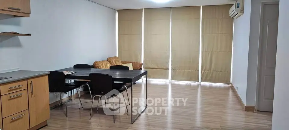 Spacious living room with modern dining area and natural light