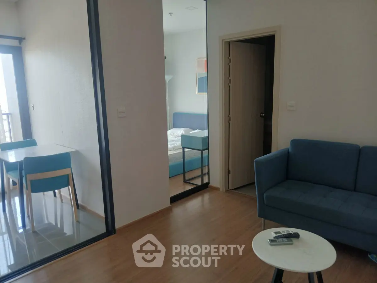 Modern apartment interior with cozy living room and dining area, featuring stylish furniture and wooden flooring.