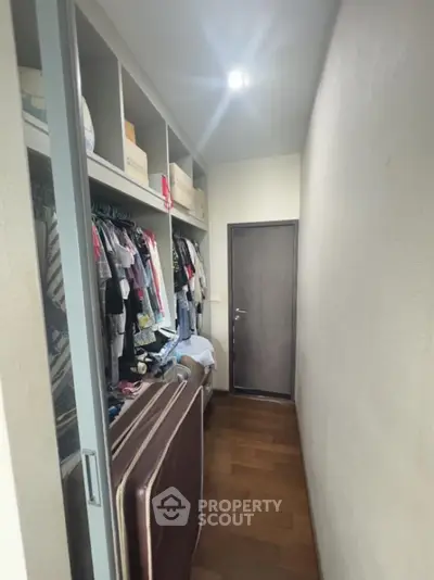 Spacious walk-in closet with ample storage and wooden flooring