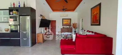 Spacious living room with modern kitchen and vibrant red sofa