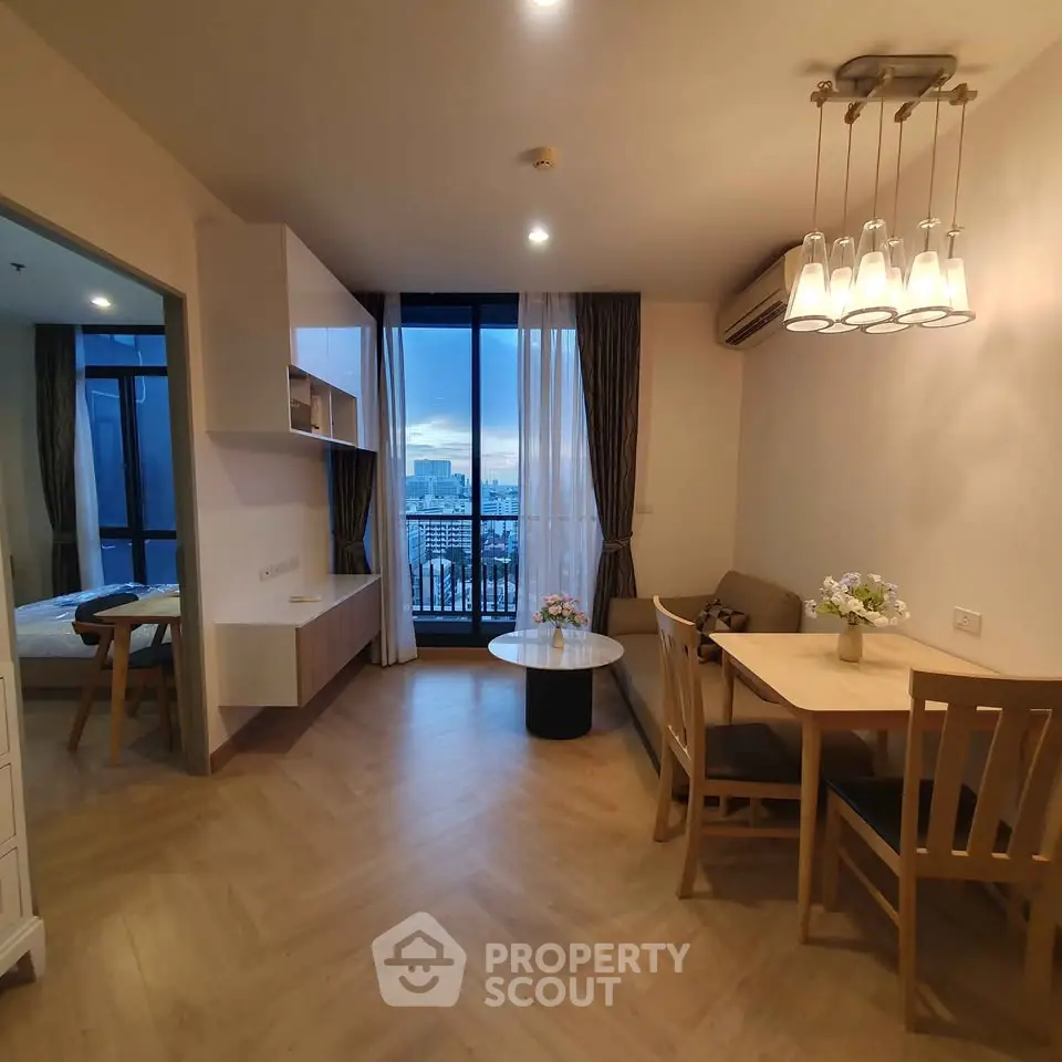 Modern living room with dining area and city view from balcony.