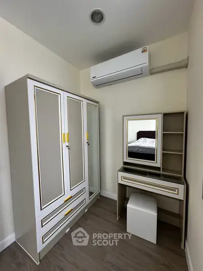 Chic bedroom corner with elegant wardrobe and vanity set, featuring modern air conditioning for ultimate comfort.