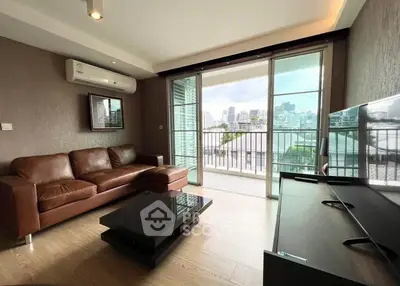 Modern living room with leather sofa and city view balcony in luxury apartment.