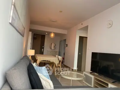 Modern living room with stylish decor and open layout, featuring a comfortable sofa and flat-screen TV.