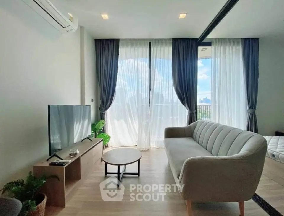 Modern living room with large windows and stylish furniture, offering a bright and airy atmosphere.