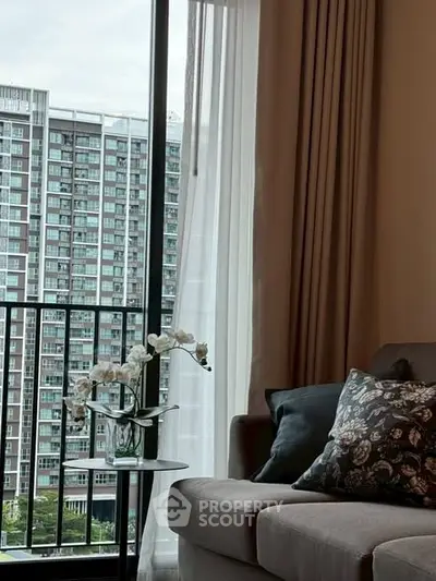 Stylish living room with cozy sofa and city view from balcony