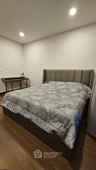 Modern bedroom with stylish bed and wooden flooring, perfect for cozy living.