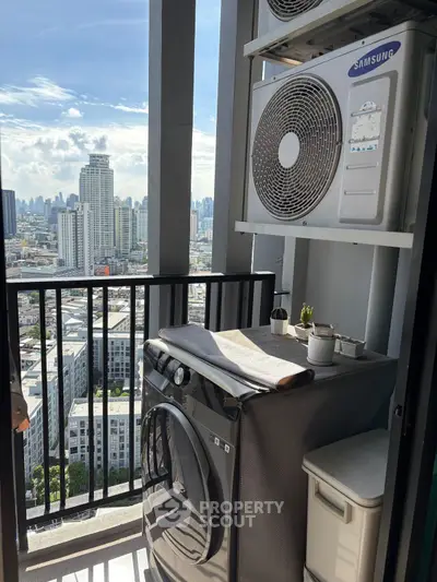 High-rise balcony with city view and laundry setup, featuring washing machine and air conditioning unit.