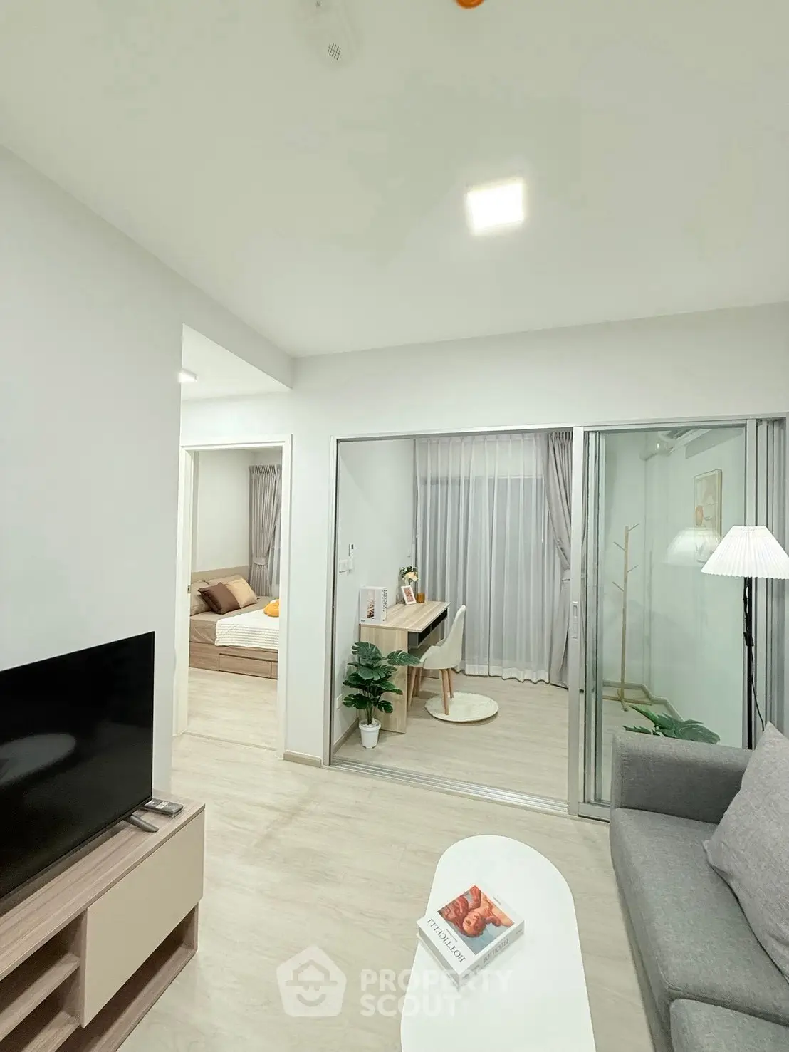 Modern living room with cozy decor and adjacent study area