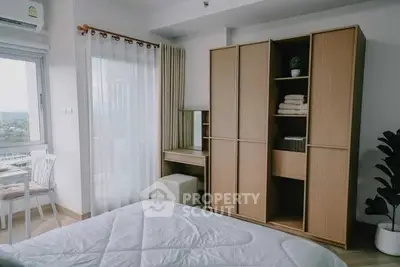 Modern bedroom with large window and stylish wooden wardrobe