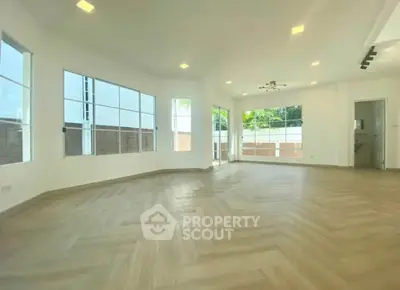 Spacious and bright living room with large windows and modern flooring