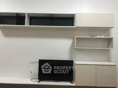Modern minimalist living room with sleek cabinetry and mounted TV