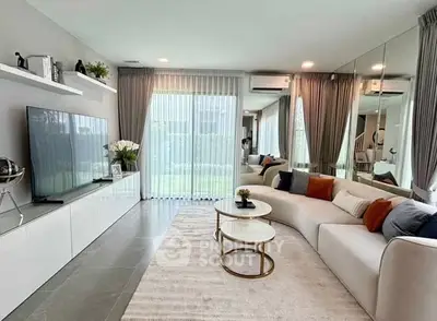 Modern living room with large TV, stylish sofa, and elegant decor