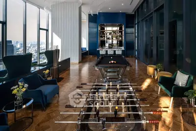 Luxurious high-rise building lounge with pool and foosball tables, offering stunning city views.