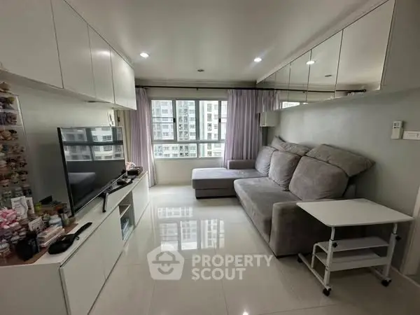 Modern living room with sleek design and large windows offering city views.