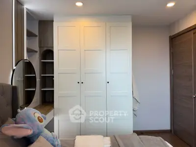 Cozy bedroom with modern wardrobe and plush decor