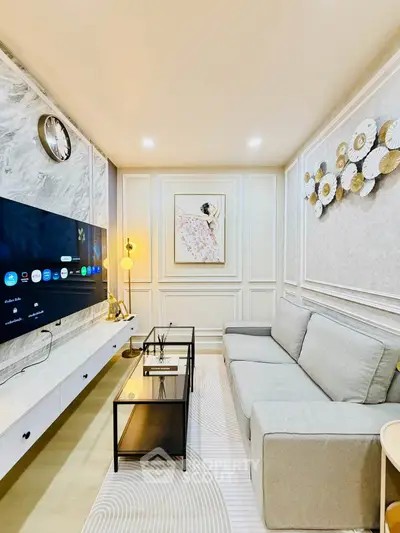 Elegant living room with modern decor, large TV, and stylish furniture in a cozy setting.