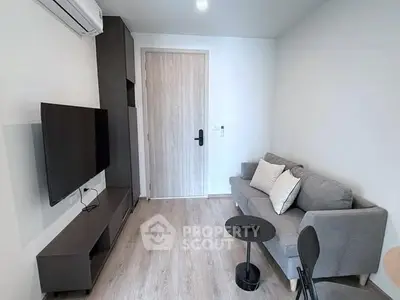 Modern living room with sleek furniture and wall-mounted TV, perfect for cozy urban living.