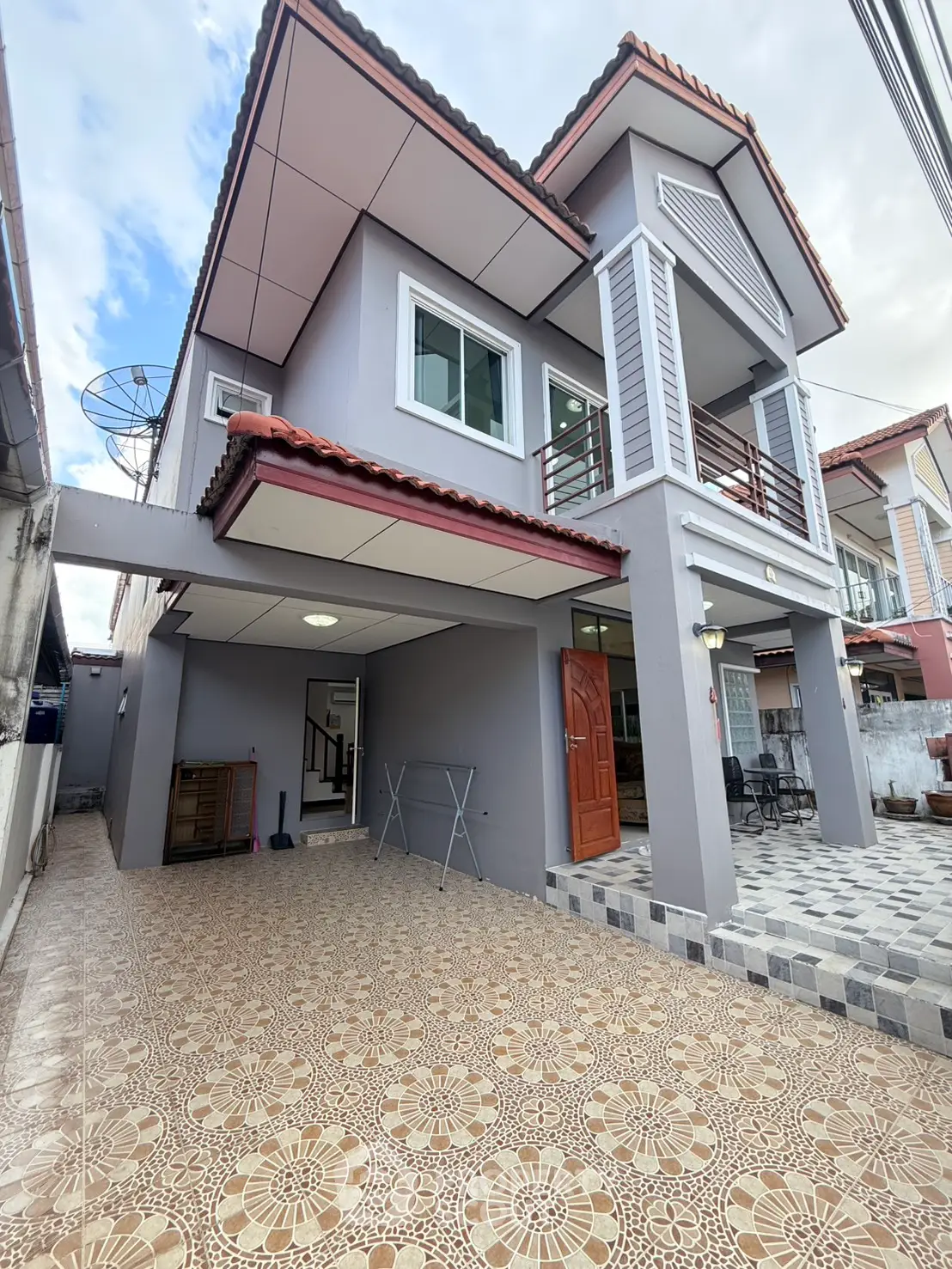 Charming two-story house with tiled patio and modern exterior design, perfect for family living.
