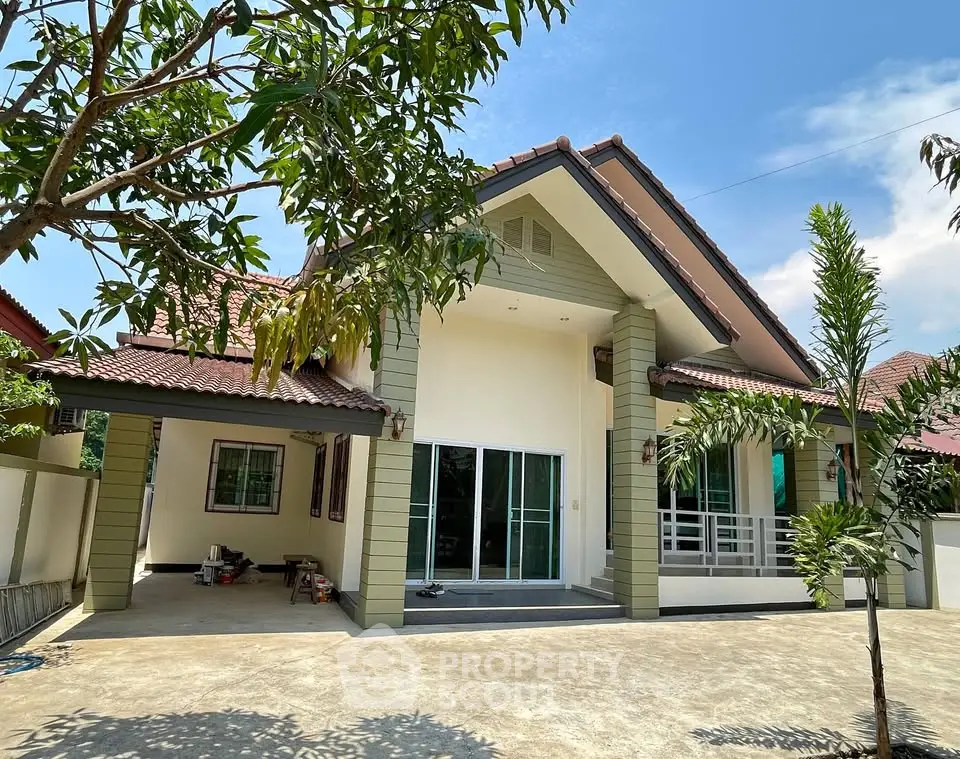 Charming single-story house with spacious driveway and lush greenery, perfect for family living.