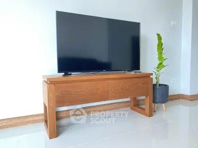 Modern living room with sleek TV stand and potted plant on glossy floor.