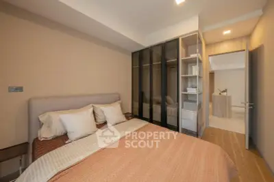 Modern bedroom with cozy bedding and built-in wardrobe in a stylish apartment.
