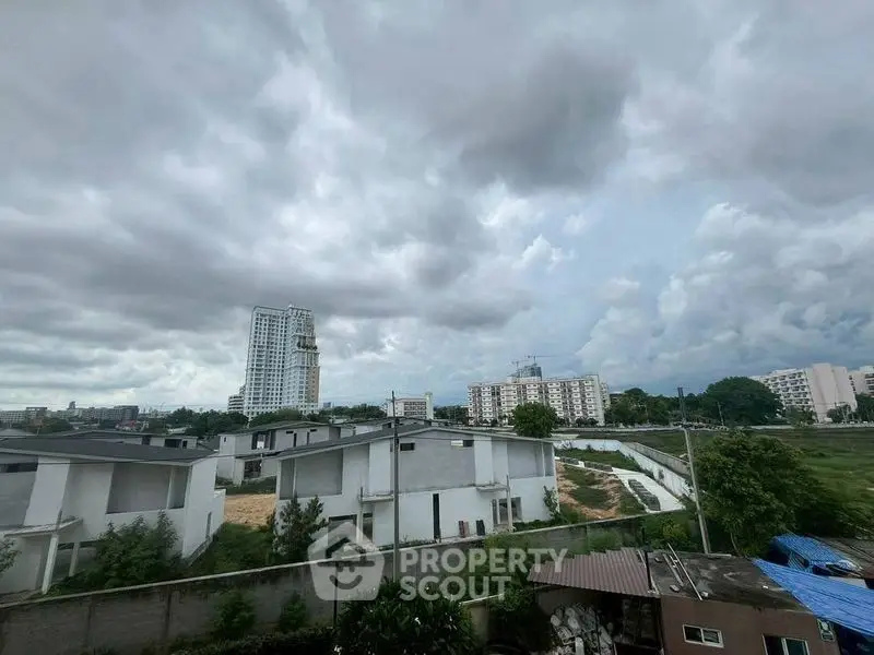 Panoramic view of residential area with cloudy sky and high-rise buildings.