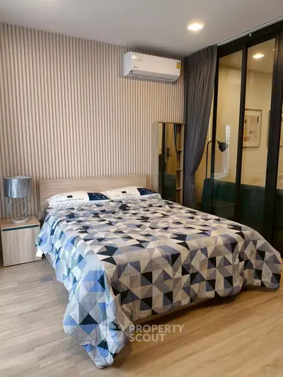 Modern bedroom with stylish decor and air conditioning in a cozy apartment.