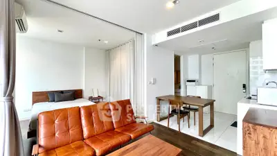 Modern studio apartment with open layout, featuring a cozy living area and compact kitchen.