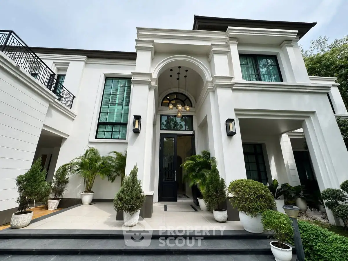 Luxurious modern villa with grand entrance and lush greenery, perfect for upscale living.