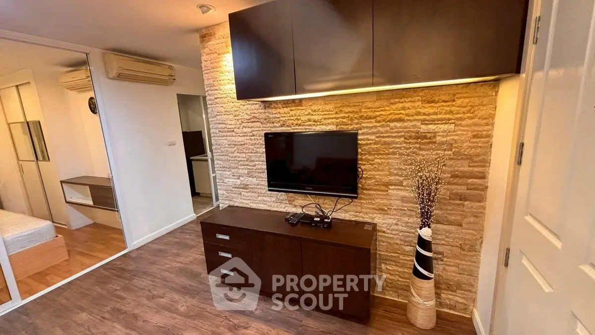 Modern living room with stylish stone accent wall and sleek dark wood furniture.