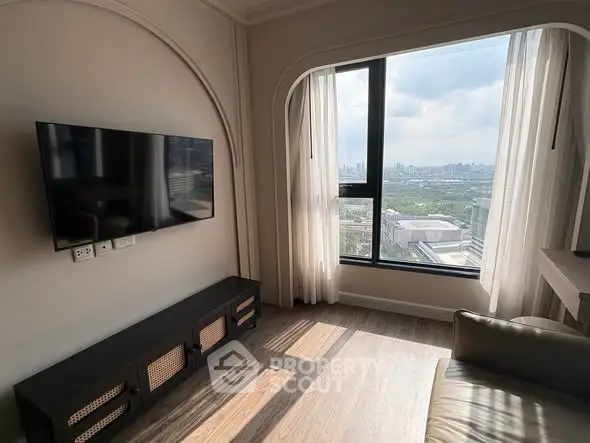 Modern living room with large window offering stunning city view, wall-mounted TV, and stylish decor.