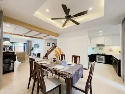 Spacious open-plan dining and living area with modern kitchen and elegant decor.