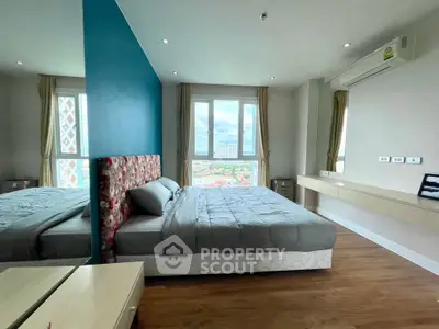 Spacious bedroom with large windows and city view in modern apartment