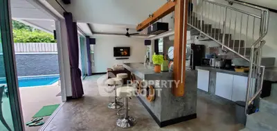 Modern open-plan living area with pool view, stylish kitchen, and sleek interior design.