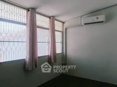 Minimalist room with large windows and air conditioning unit, perfect for natural light and comfort.