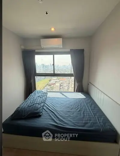 Cozy bedroom with city view and natural light, featuring a comfortable bed and air conditioning.