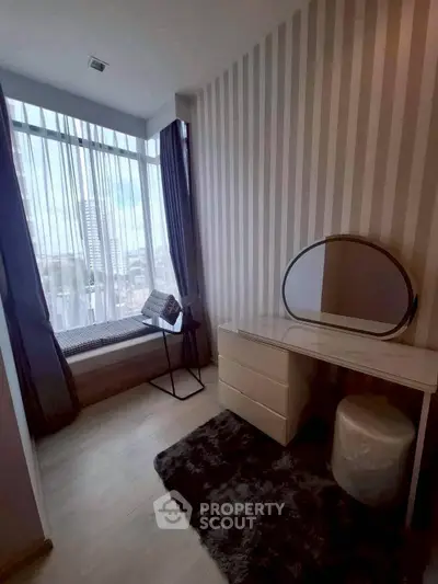 Chic modern bedroom with stylish vanity and large window offering city views.