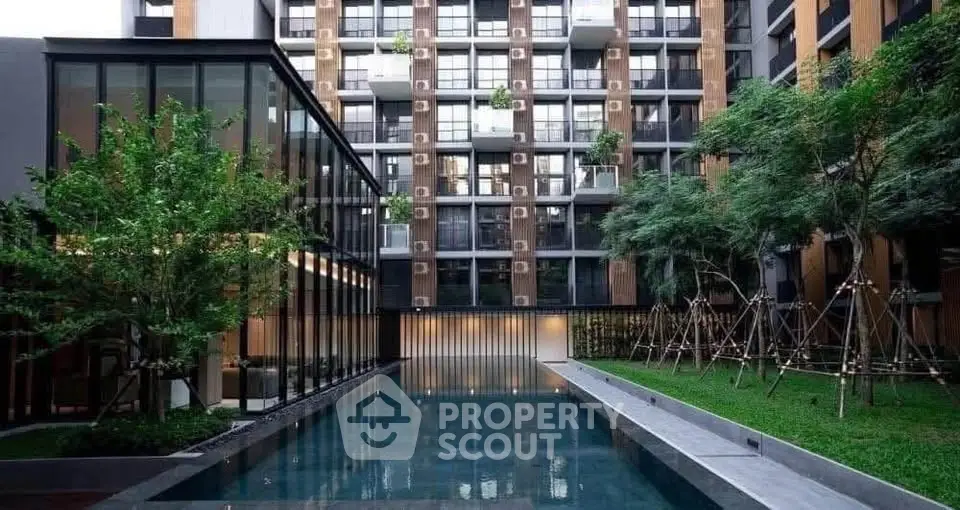 Modern apartment complex with sleek pool and lush greenery