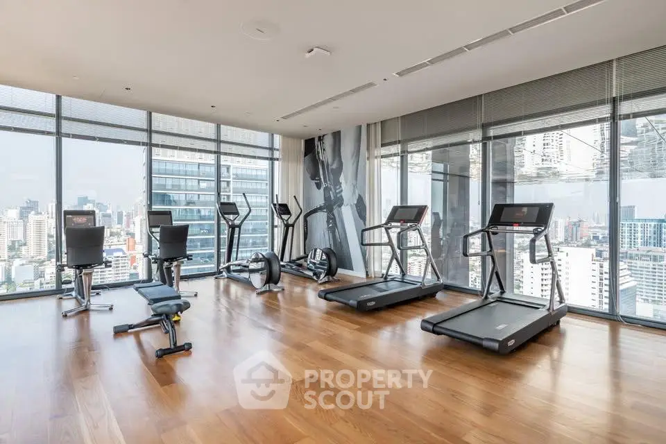 Luxurious high-rise gym with panoramic city views and modern fitness equipment.
