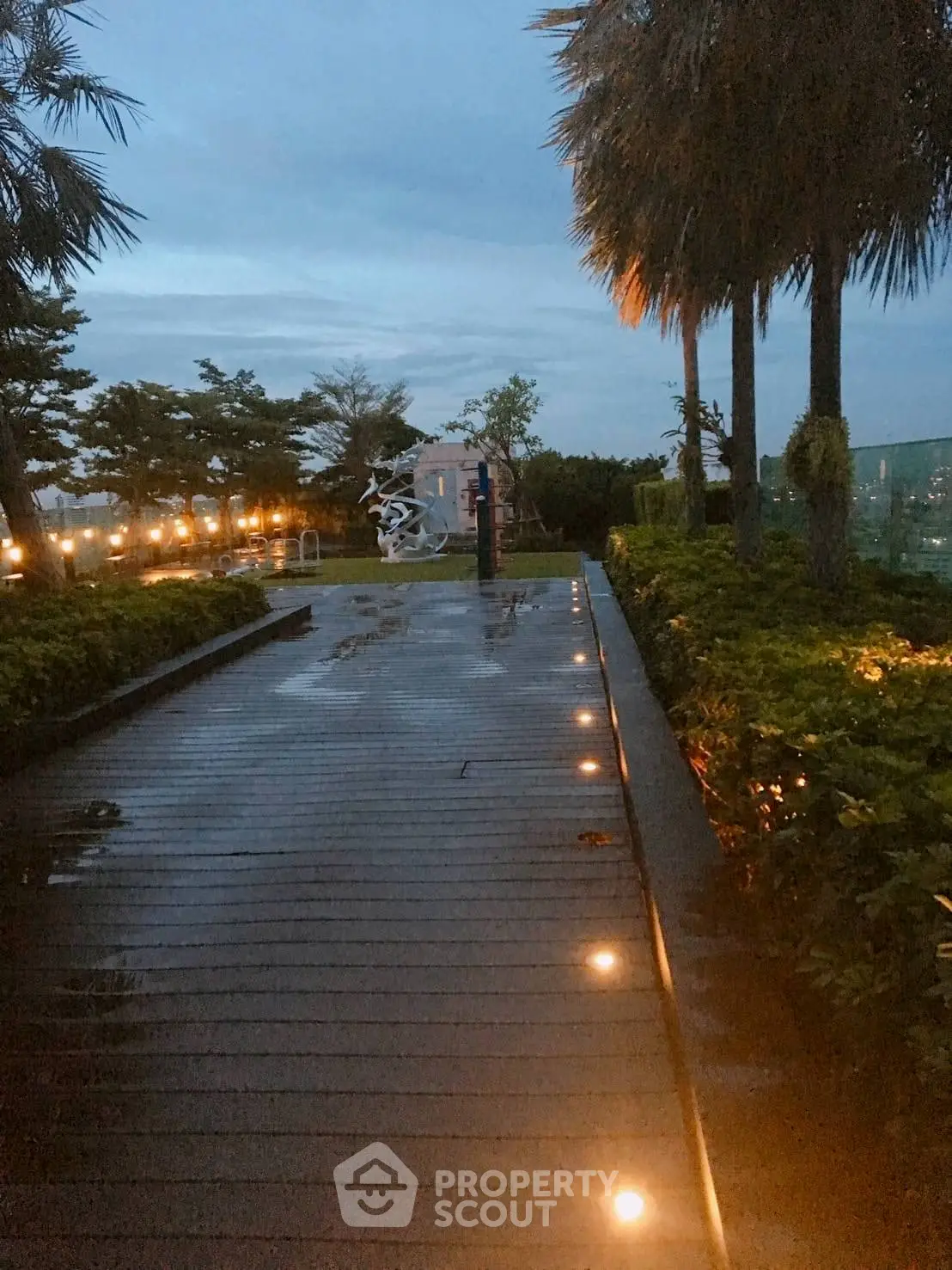 Stunning rooftop garden with ambient lighting and lush greenery at dusk.