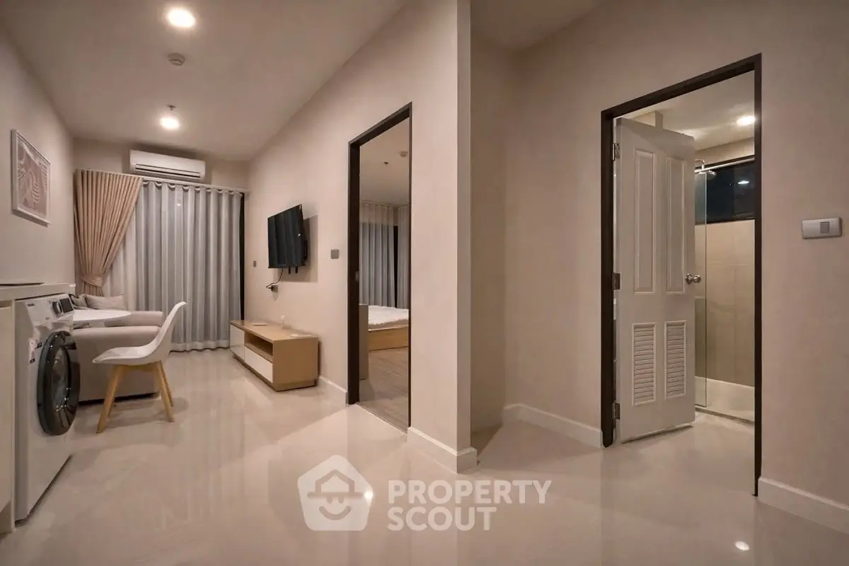 Modern apartment interior with sleek design, featuring a washing machine and stylish furniture.