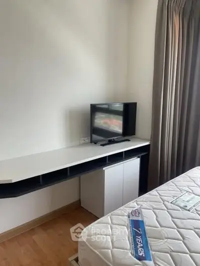 Cozy bedroom with modern TV setup and natural light