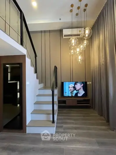 Modern duplex living room with stylish lighting and sleek staircase design.