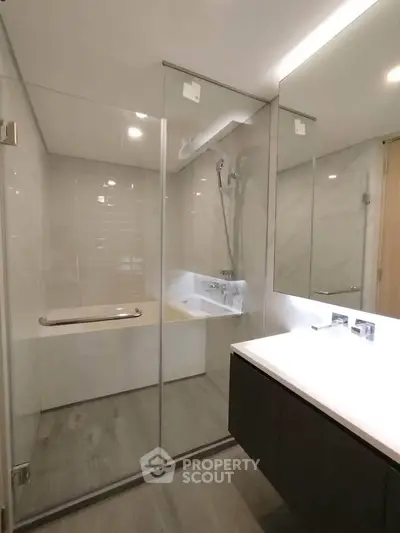Modern bathroom with glass shower and sleek vanity in luxury apartment