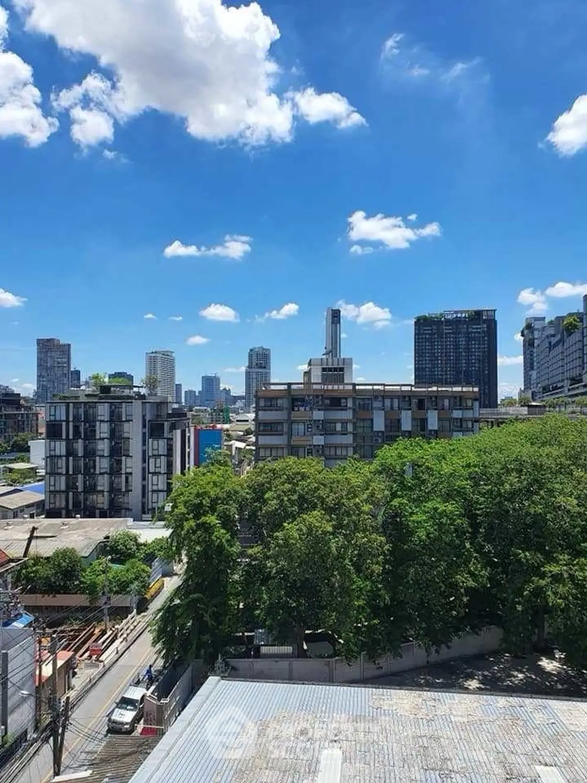 Stunning cityscape view with lush greenery and modern buildings under a clear blue sky.