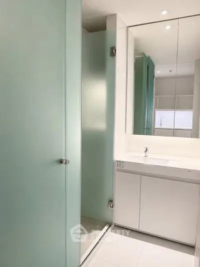 Modern bathroom with sleek frosted glass shower and minimalist vanity
