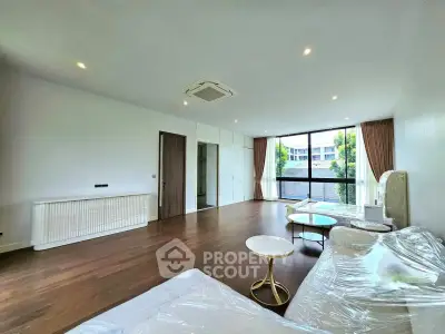 Spacious modern living room with large windows and elegant furniture in a luxury apartment.
