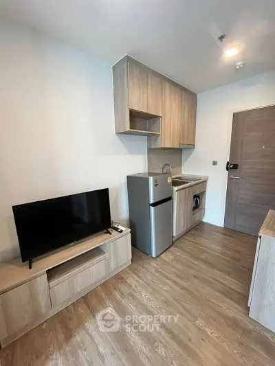 Modern compact living room with kitchenette and stylish wooden flooring